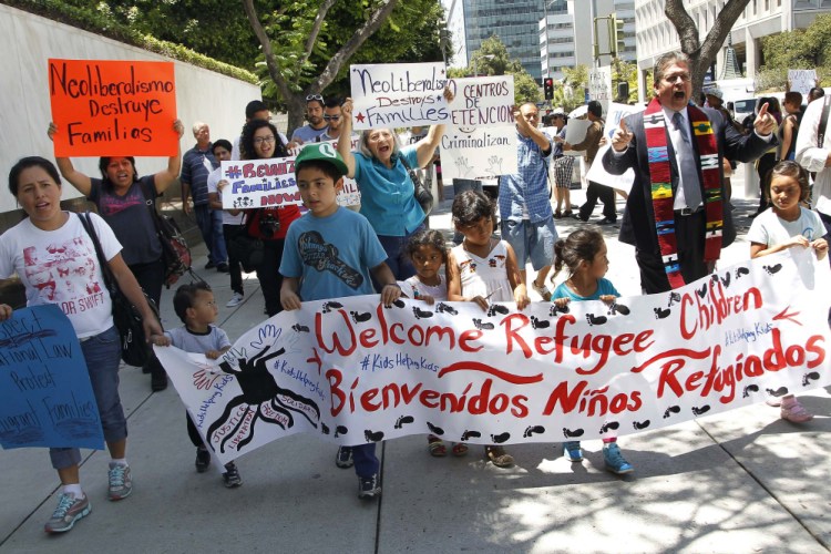 Immigrant families and children’s advocates rally in response to President Barack Obama’s statement on the crisis of unaccompanied children and families illegally entering the United States, outside the Los Angeles Federal building Monday.