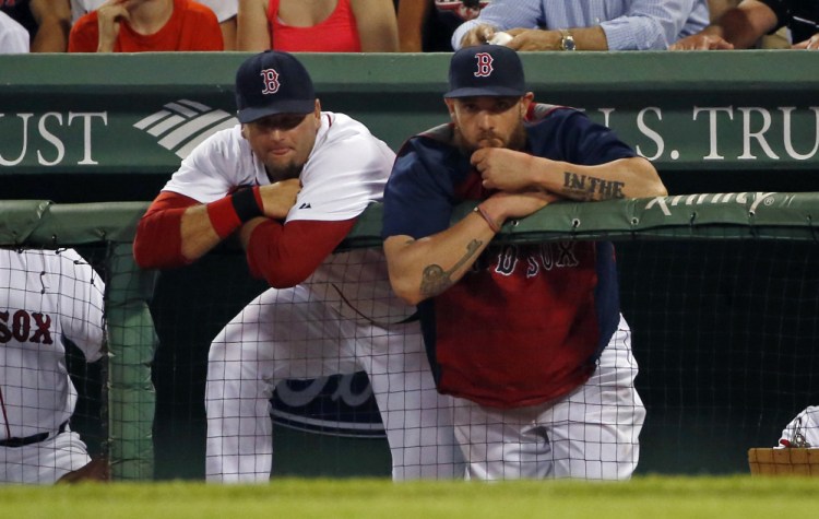 Red Sox catcher A.J. Pierzynski, left, and left fielder Jonny Gomes watch from the dugout in the ninth inning of an 8-3 loss Tuesday night in Boston.