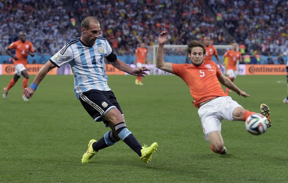 Netherlands’ Daley Blind, right, slides in to block a cross from Argentina’s Pablo Zabaleta during the World Cup semifinal soccer match between the Netherlands and Argentina at the Itaquerao Stadium in Sao Paulo Brazil, on Wednesday.