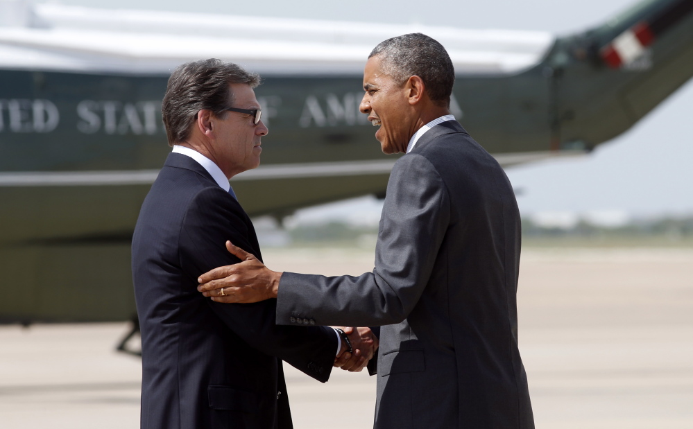 Texas Gov. Rick Perry greets President Obama upon his arrival in Dallas to discuss a surge of young people crossing the U.S.-Mexico border.