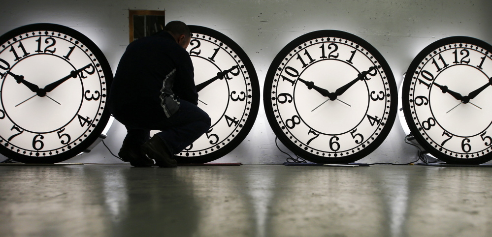 An employee at a clock factory in Medford, Mass., adjusts some of his company’s clocks to account for daylight-saving time last year. Utah is the latest state to consider doing away with daylight-saving time.
