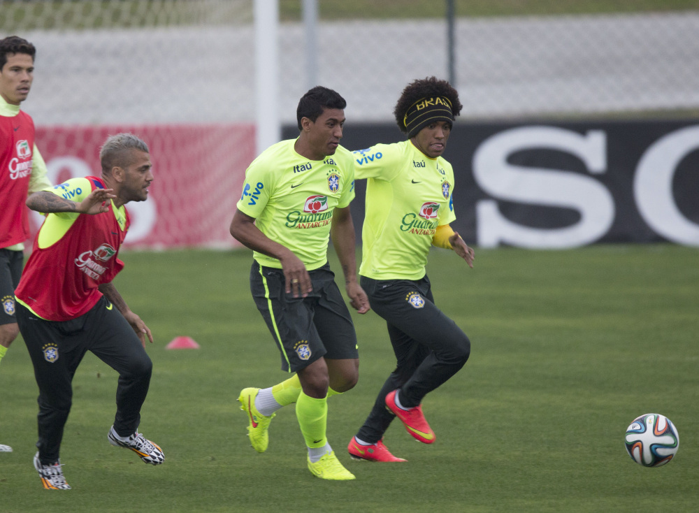 Now comes the game that nobody really wants to play – for third place – but Brazil was back in training Thursday, preparing to meet the Netherlands on Saturday. Willian, right, Paulinho, center, and Daniel Alves fight for the ball at Teresopolis, Brazil.