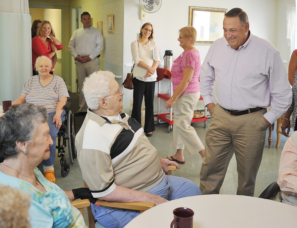 Gov. Paul LePage chats with Ethel and Dominic Oddi at the Coastal Manor nursing home in Yarmouth on Friday. They and others like them will be a key voting bloc for whomever is elected to the Blaine House in November.