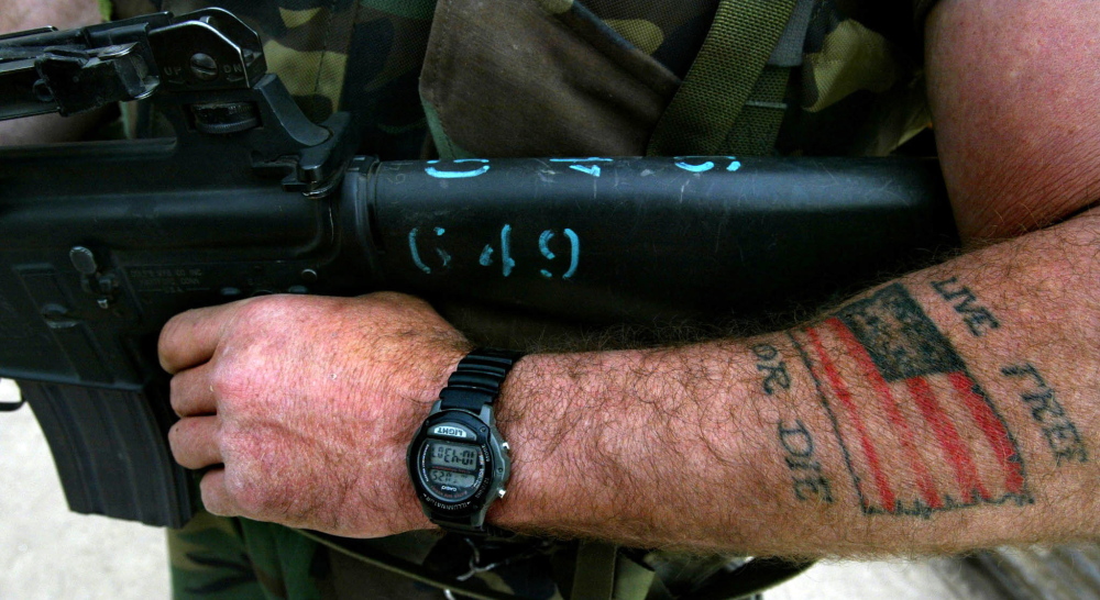 A U.S. soldier bares a tattooed arm while carrying his weapon in the Iraq town of Umm Qasr in 2003.