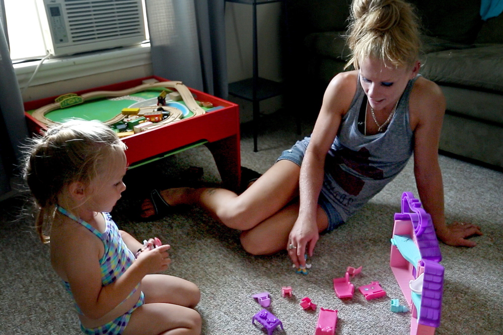 Alyssa Gray plays with her mother, Dawn Moores, in their Bucksport apartment. Alyssa is the daughter of Adam Gray.