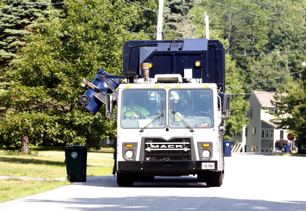 A Pine Tree Waste Services truck driver empties a recycling container in Biddeford last week. The city tripled its recycling rate in the first year of curbside pickup, reducing the trash in its waste stream and saving about $220,000 in tipping fees.