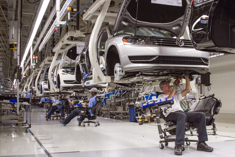 In this July 12, 2013, photo, employees at the Volkswagen plant in Chattanooga, Tenn., work on the assembly of a Passat sedan.