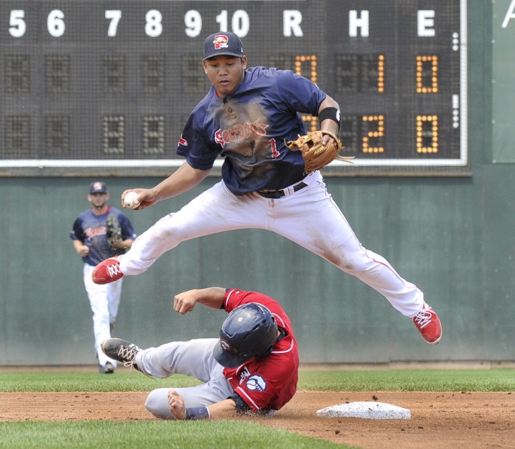 Portland’s  Heiker Meneses is taken out of a double play as Fisher Cats Derrick Chung slides wide of second at Hadlock Field in Portland.
John Patriquin/Staff Photographer