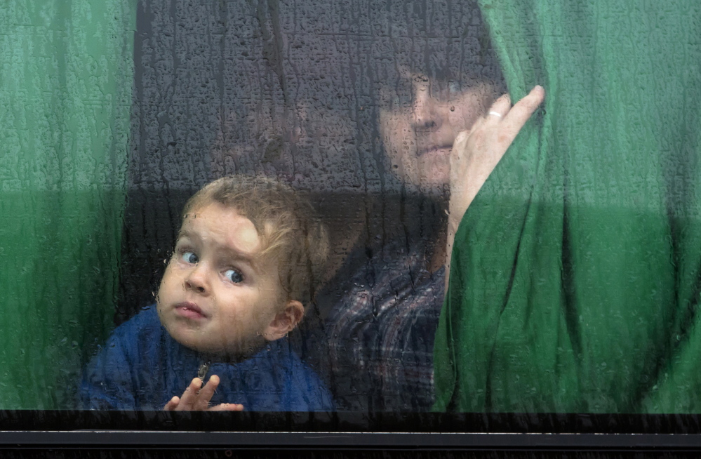 People in the city of Donetsk, eastern Ukraine, look out a bus window as they depart for Russia on Monday. Five busloads of internally displaced people from four towns left Monday morning for the Rostov region in Russia to ask for refugee status there.

The Associated Press