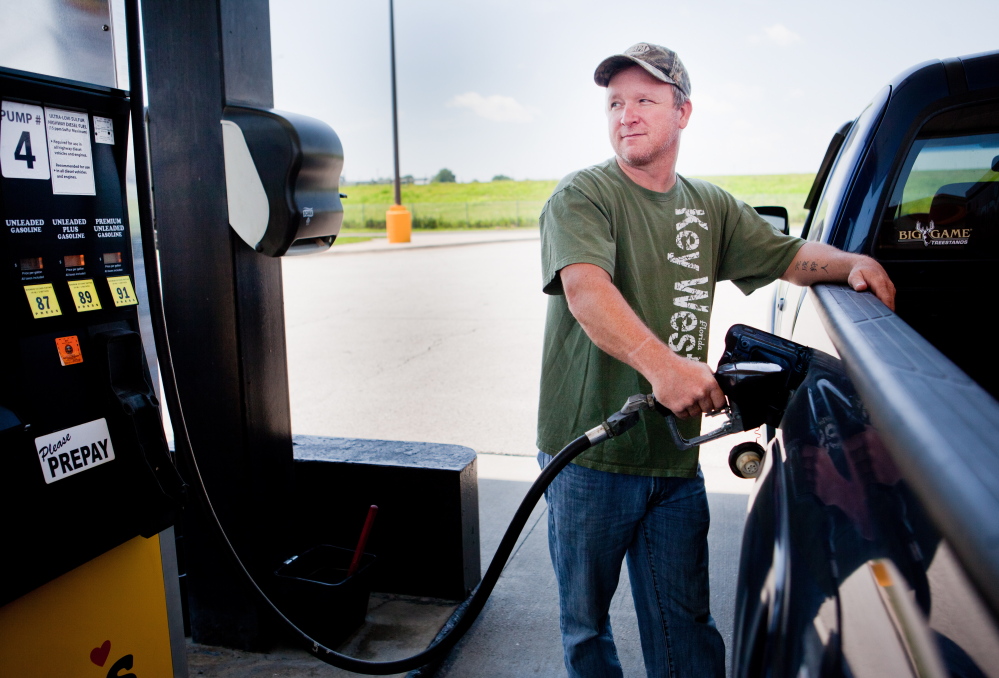 Lance Thompson fills up in Missouri. Fifty-eight percent of people say they’re spending more on gas this summer.