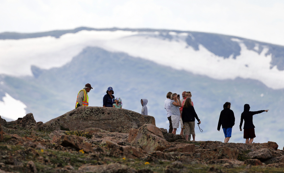 Volunteer Tundra Guardian Rick Beesley, far left, talks with visitors at a scenic overlook off Trail Ridge Road at Rocky Mountain National Park, west of Estes Park, Colo., on Monday. Lightning killed two people in the park over the weekend.
