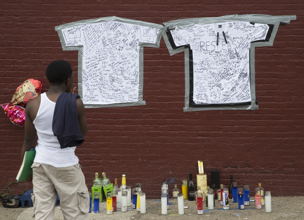 A pedestrian looks at a memorial to Lawrence Campbell, who allegedly shot and killed rookie Jersey City police officer Melvin Santiago in Jersey City, N.J., on Monday.