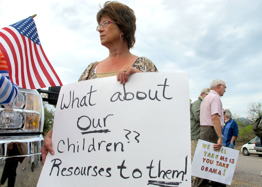 Deborah Pfaff joins other protesters near the entrance to a juvenile facility in Oracle, Ariz., where federal officials delayed a bus of Central American children from arriving. Pfaff was one of dozens of protesters on both sides of the immigration debate who showed up in the town near Tucson on Tuesday following reports that 40 children would arrive.