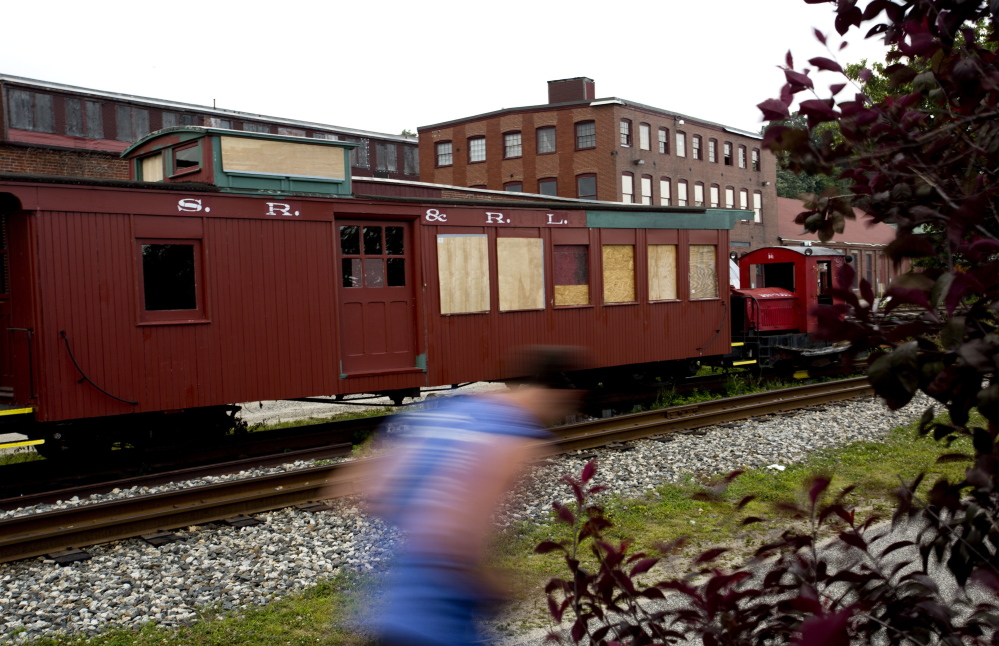 A runner makes his way past a train car belonging to the Narrow Gauge Railroad that is boarded up after it was vandalized. The director of the railroad company and museum says damage is estimated at more than $3,800.