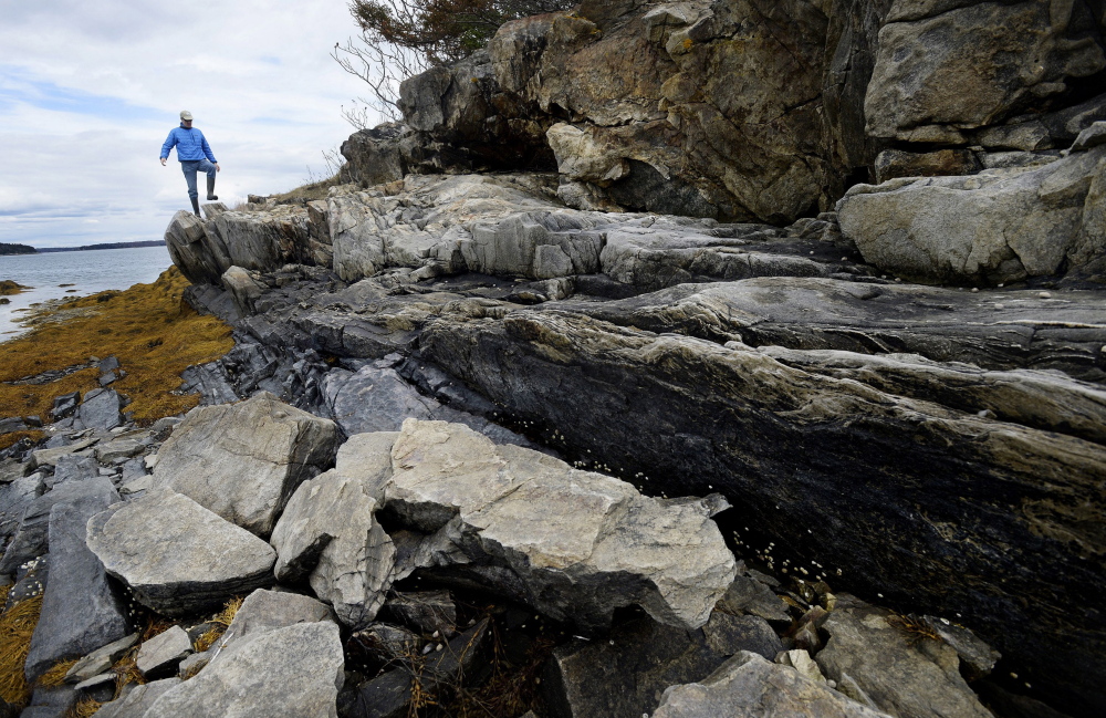 Richard Knox of the Maine Coast Heritage Trust walks along the shore of East Gosling island in May. The trust plans to add the island to its inventory of protected Casco Bay sites. Shawn Patrick Ouellette /2014 Press Herald file