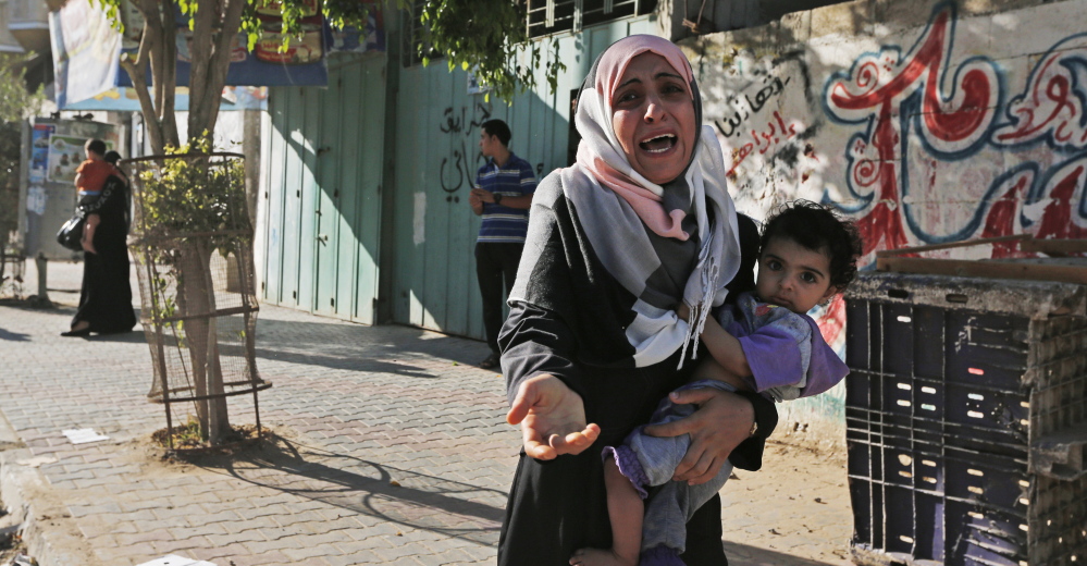 A woman cries as Palestinians flee their homes Wednesday in the Shajaiyeh neighborhood of Gaza City, after Israel airdropped leaflets warning people to leave the area.