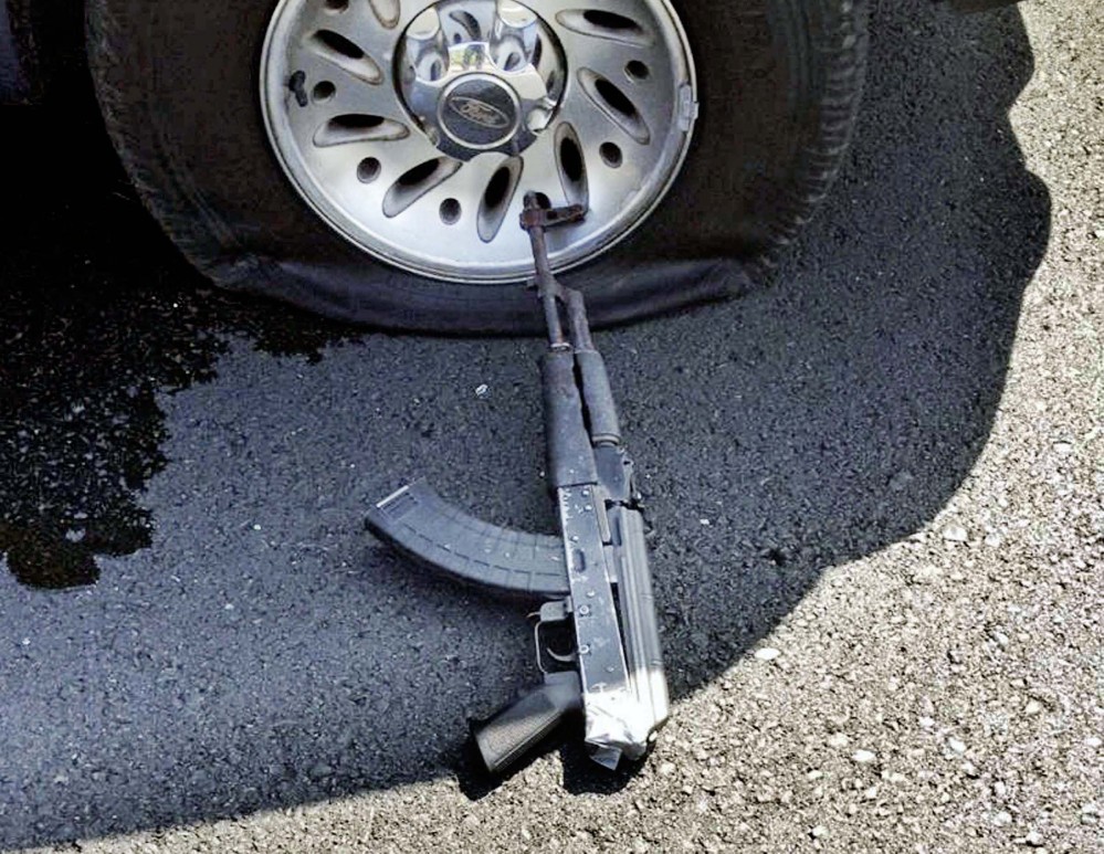 In the aftermath of the Stockton, Calif., robbery, a tire on the robbers’ car is shown shot out and a firearm lies on the ground.