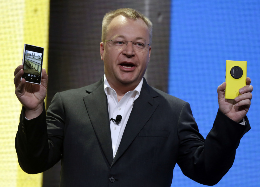 Then-Nokia CEO Stephen Elop shows the company’s Nokia Lumia 1020 in New York in 2013. Elop, now Microsoft’s executive vice president, sent employees a memo detailing its job cut plans. Microsoft on Thursday said it will cut up to 18,000 jobs over the next year, with about 12,500 related to Microsoft’s acquisition of Nokia’s phone business in April.