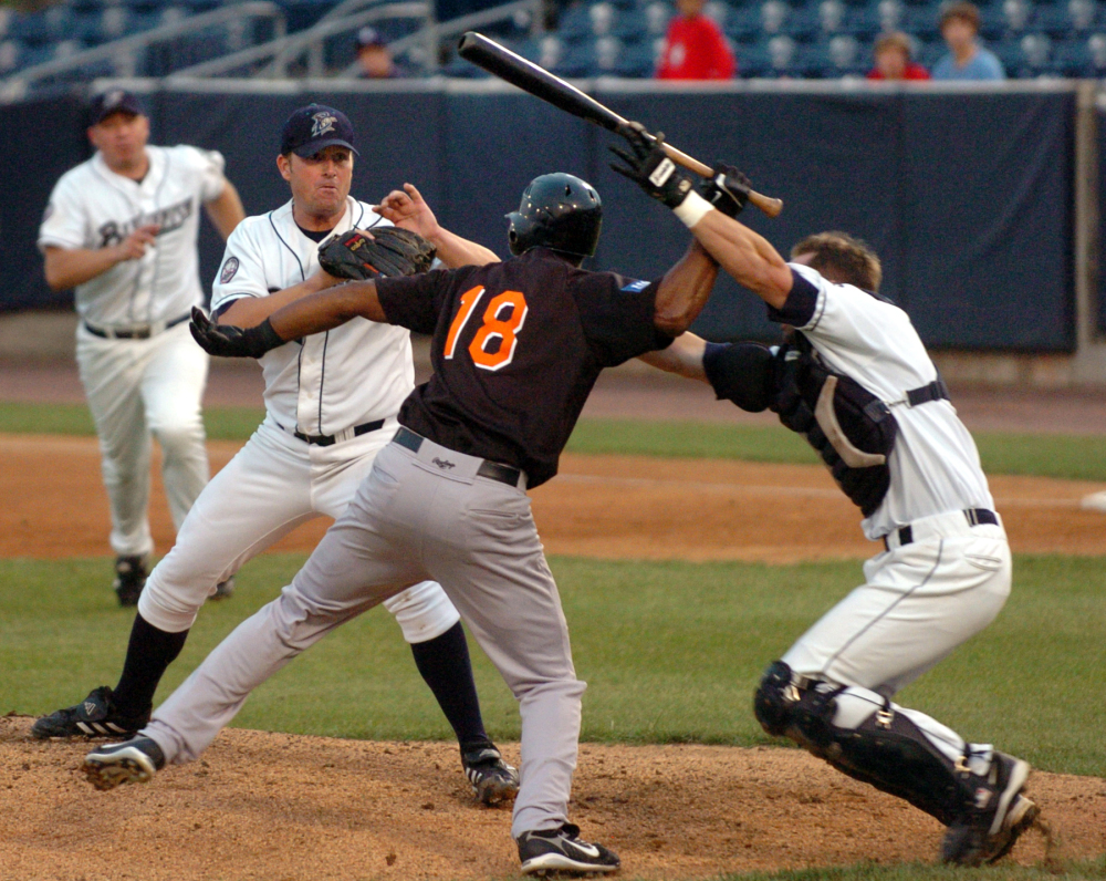 Bridgeport Bluefish catcher John Nathans, right, tries to prevent Long Island Duck’s Jose Offerman (18) from hitting Bluefish pitcher Matt Beech with a bat during a fight in the first inning of an Atlantic League minor league baseball game in Bridgeport, Conn., in August 2007.