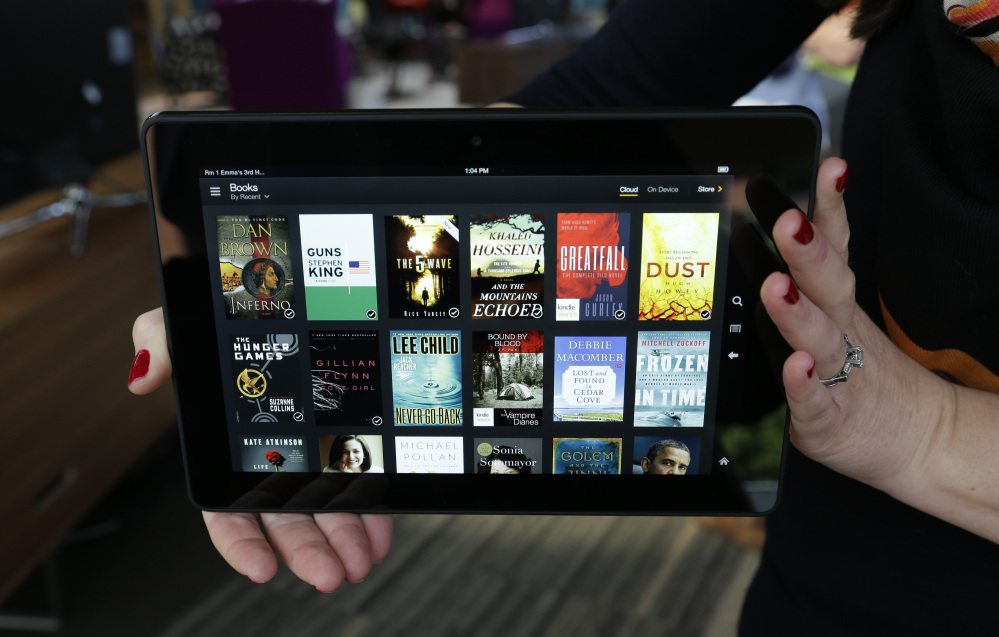 The 8.9-inch Amazon Kindle HDX tablet computer is held up for a photo in Seattle. Amazon is rolling out a new subscription service that will allow unlimited access to thousands of electronic books and audiobooks for $9.99 a month.