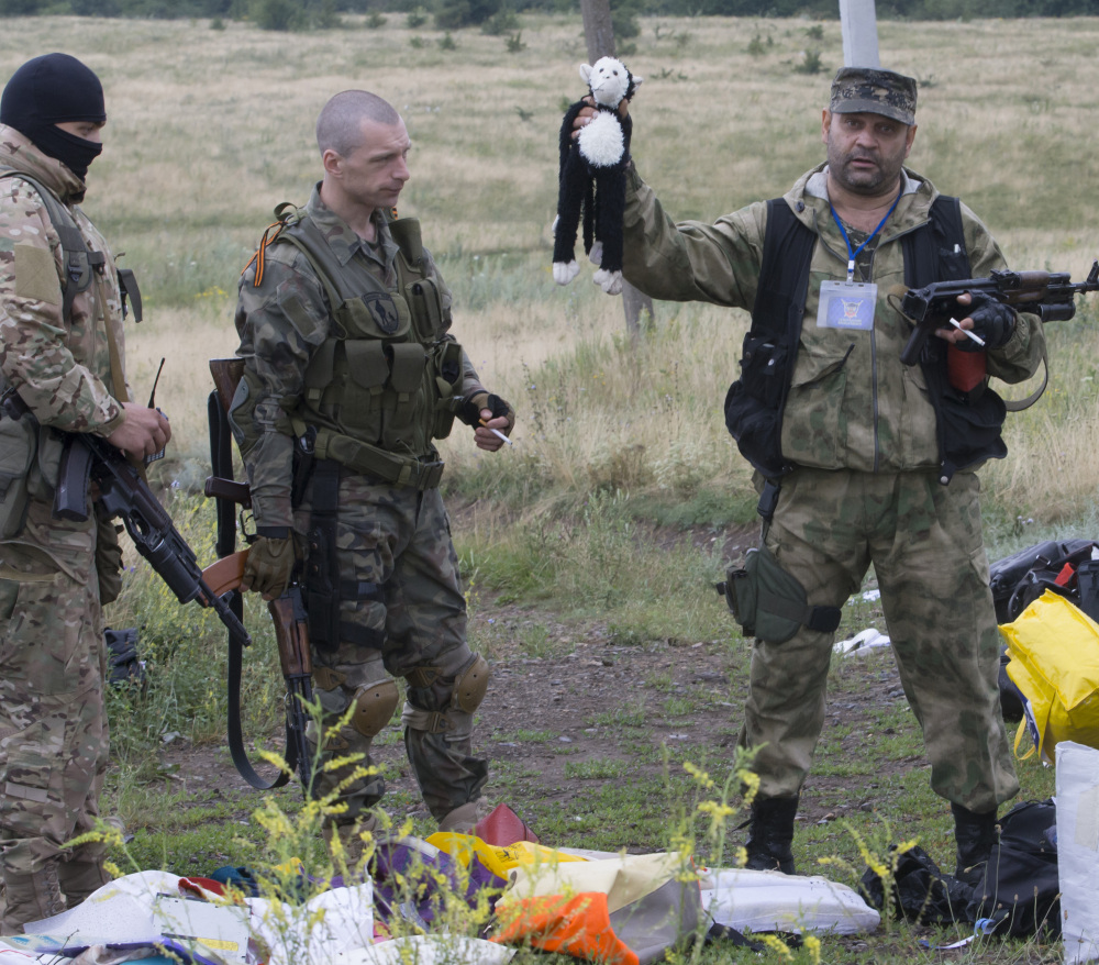 A pro-Russian fighter holds up a toy found among the debris at the crash site of a Malaysia Airlines jet near the village of Hrabove in eastern Ukraine on Friday. The fate of the plane’s black box remains unknown, with neither side claiming possession of it.