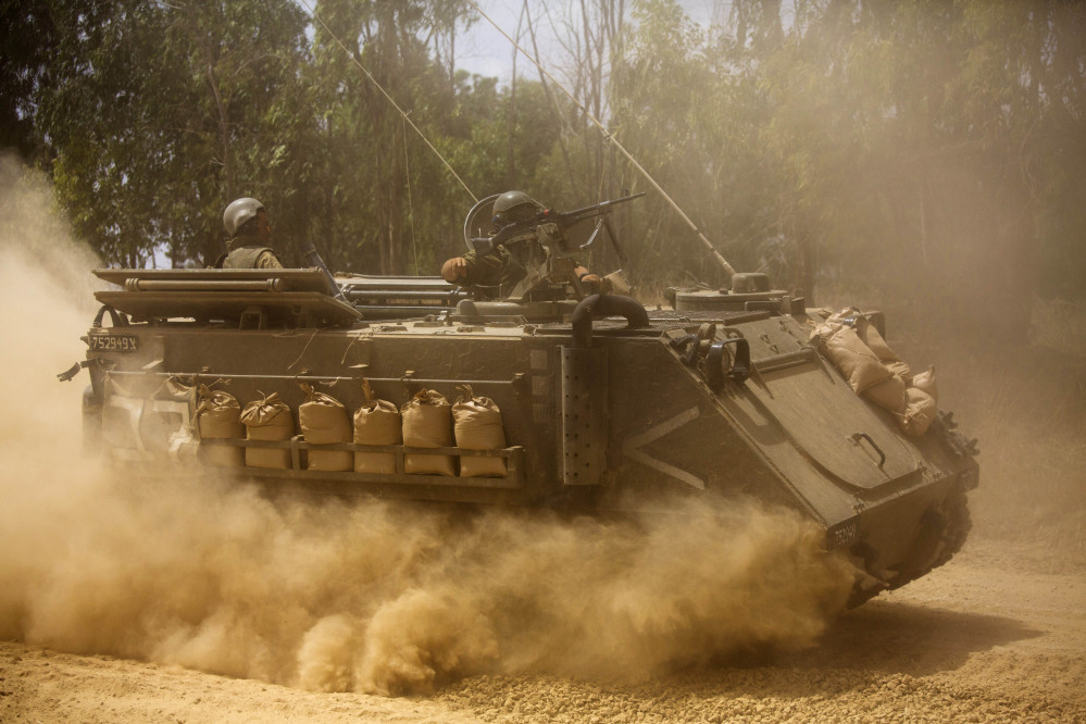 An Israeli armored personnel carrier moves near the Israel and Gaza border on Saturday. Israel pounded Hamas rocket launchers, uncovered more than a dozen cross-border tunnels and engaged in gunbattles with Palestinian militants.