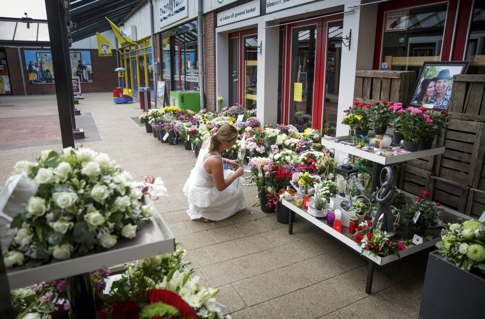 A woman leaves flowers  in Volendam, Netherlands, on Saturday for victims of the crash. 