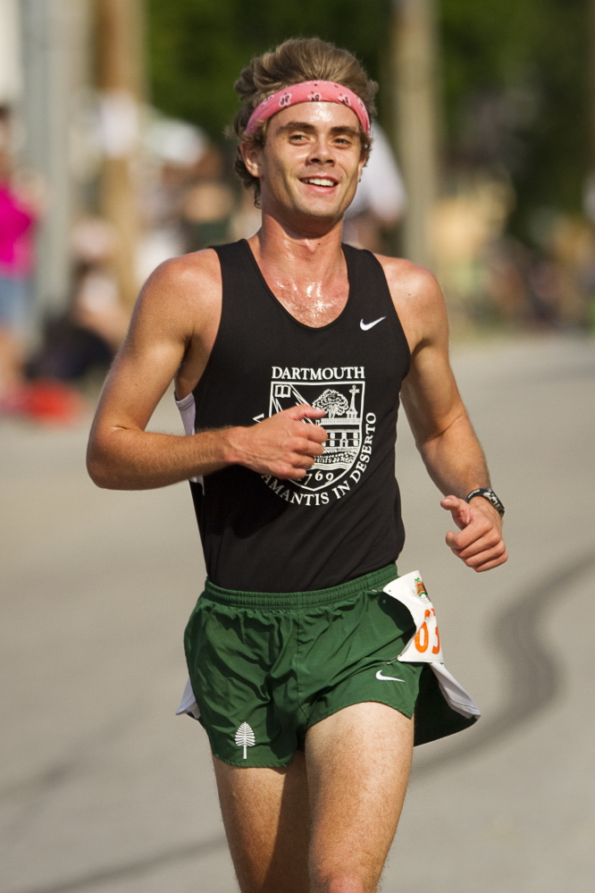Winner Will Geoghagan of Brunswick smiles as he approaches the finish line in winning the 2014 Yarmouth Clam Festival 5 Mile run on Saturday in Yarmouth.