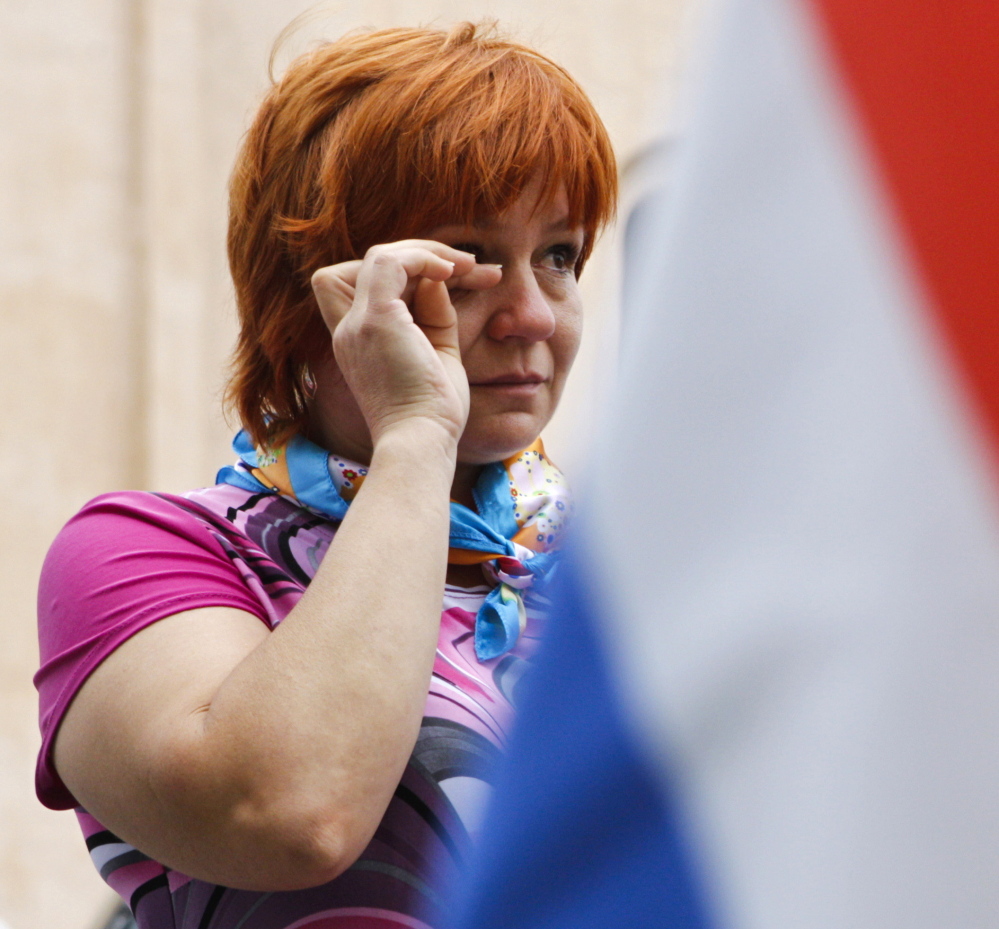 A woman weeps as she looks at flowers and messages left outside the Dutch embassy in Kiev on Saturday.