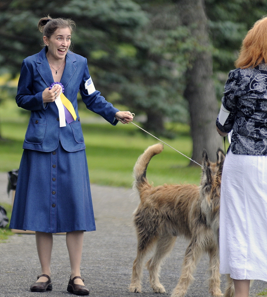 Celestia Lensky of New Hampshire clutches ribbons her dog won in the show Sunday.