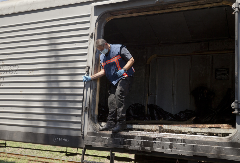 Peter Van Vilet, team leader of Netherlands' National Forensic Investigations Team exits a carriage while inspecting a refrigerated train loaded with the bodies of passengers moved from the crash site of Malaysia Airlines Flight 17, located 15 kilometers (9 miles) away, in Torez, eastern Ukraine, Monday, July 21, 2014. Another 21 bodies have been found in the sprawling fields of east Ukraine where Malaysia Airlines Flight 17 was downed last week, killing all 298 people aboard. (AP Photo/Vadim Ghirda)