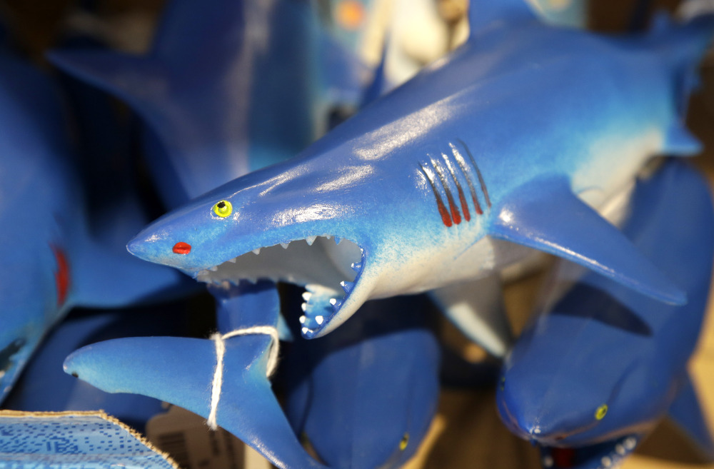 A bin is filled with plastic toy sharks in a souvenir shop in Chatham, Mass.