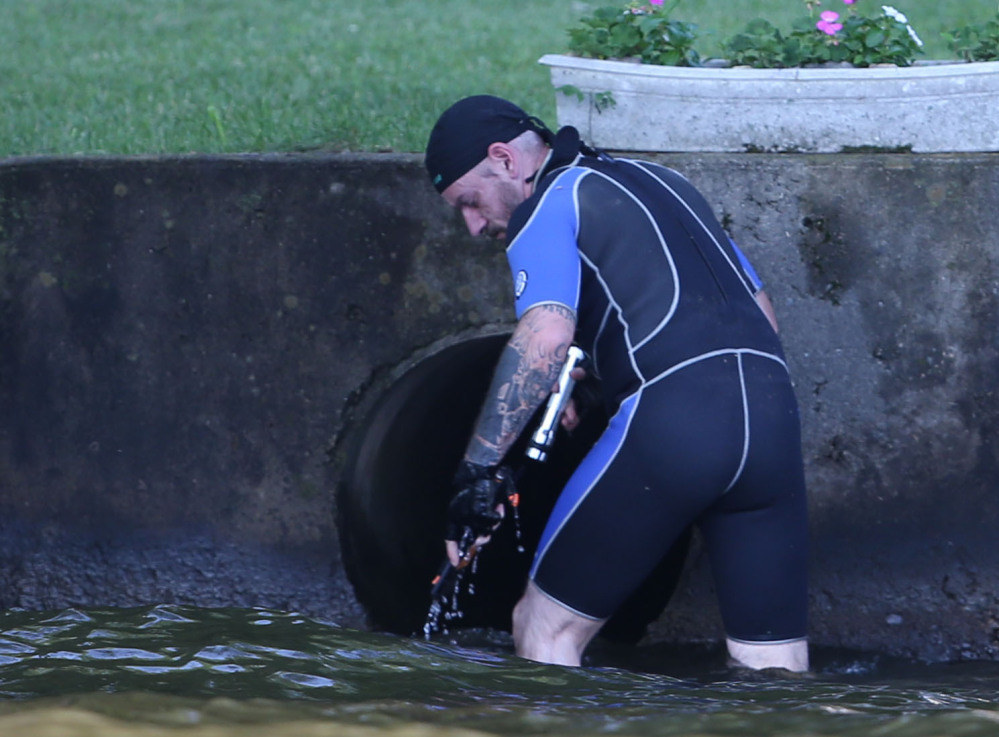 Gerald Andrejcak, assistant director of Common Sense for Animals in Warren County, N.J, searches a large drainage pipe for a large snake in Lake Hopatcong near Jefferson, N.J.
Associated Press photos