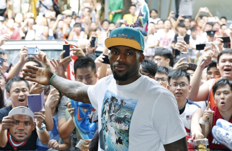 NBA star LeBron James poses with his fans during a promotional event at a shopping district in Hong Kong as part of his China tour Wednesday.