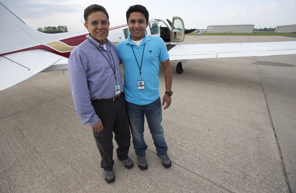Babar Suleman and son Haris Suleman, 17, stand next to their plane at an airport in Greenwood, Ind., on June 19 before taking off for an around-the-world flight.