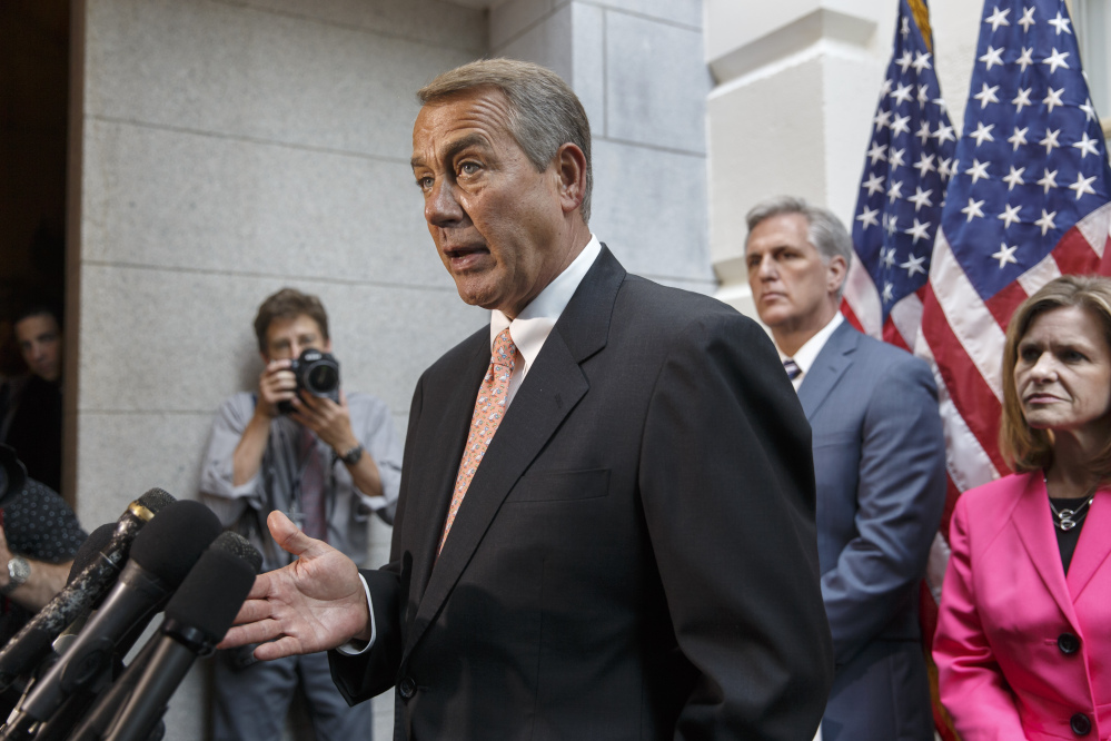 Speaker of the House John Boehner, R-Ohio, joined at right by incoming Majority Leader Rep. Kevin McCarthy, R-Calif., and Rep. Lynn Jenkins, R-Kan., talks with reporters  on Capitol Hill in Washington on Wednesday, following a Republican strategy session.