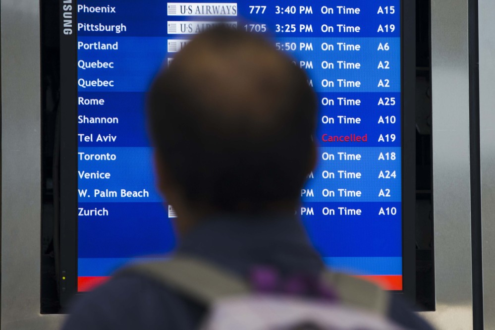 A traveler views a departures board Tuesday at the Philadelphia International Airport after the Federal Aviation Administration had told U.S. airlines they were prohibited from flying to Tel Aviv after a Hamas rocket exploded nearby.