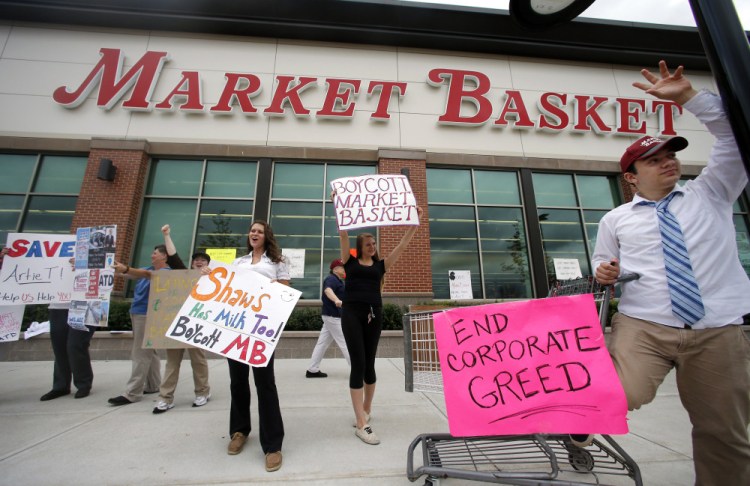 Market Basket employees Rees Gemmell, far right, and colleagues acknowledge passing supporters as they picket in front of the supermarket Thursday in Haverhill, Mass., on July 25.