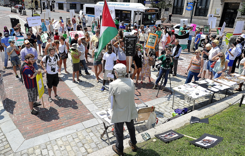 Bob Schaible of Buxton, chair of Maine Voices for Palestinian Rights, on Friday urges the signing of petitions by protesters in Monument Square who condemn Israel's bombing of Gaza. Gordon Chibroski/Staff Photographer