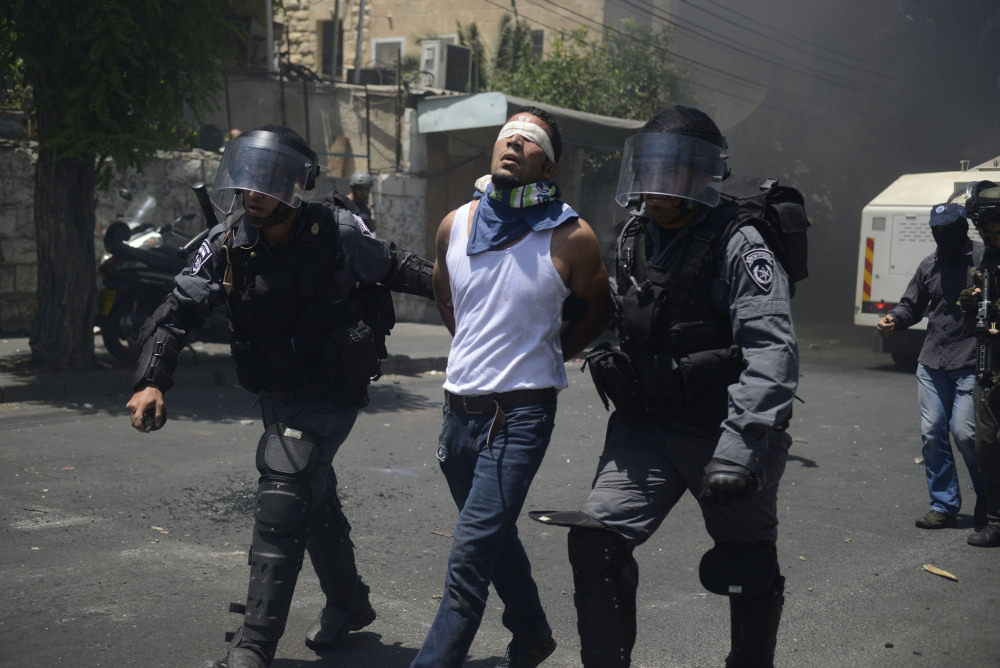 Israeli police officers detain a Palestinian man during clashes near Jerusalem’s Old City on Friday.
