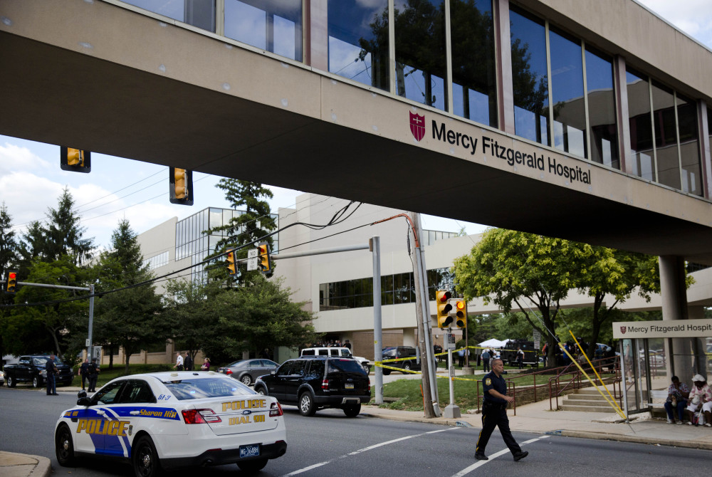 An officer walks near the scene of a shooting Thursday at Mercy Fitzgerald Hospital in Darby, Pa. The shooting at the suburban Philadelphia hospital campus killed one worker.