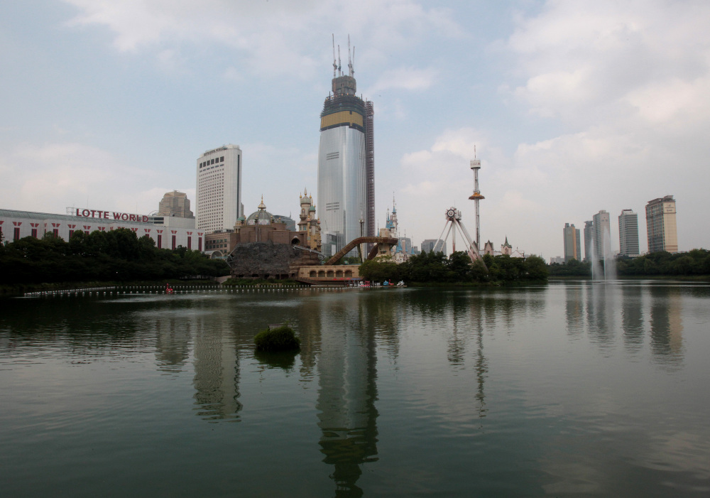 The Lotte World Tower is under construction near Seokchon Lake in Seoul, South Korea, this month. Problems such as falling lake levels and sinkholes in residential neighborhoods have led to an official review of the project, reassessing an ethos of “progress first, safety last” that was largely unquestioned as the country rapidly industrialized.
