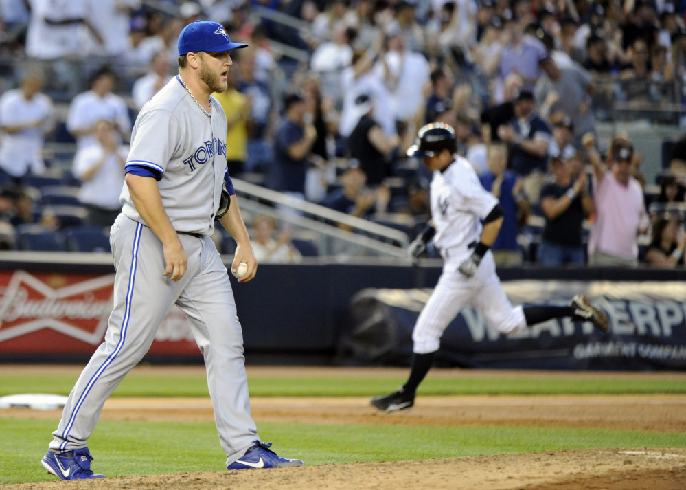 Toronto’s Mark Buehrle shows frustration as New York’s  Ichiro Suzuki, right, rounds the bases with a third-inning three-run homer during the Yankees’ victory Friday night.