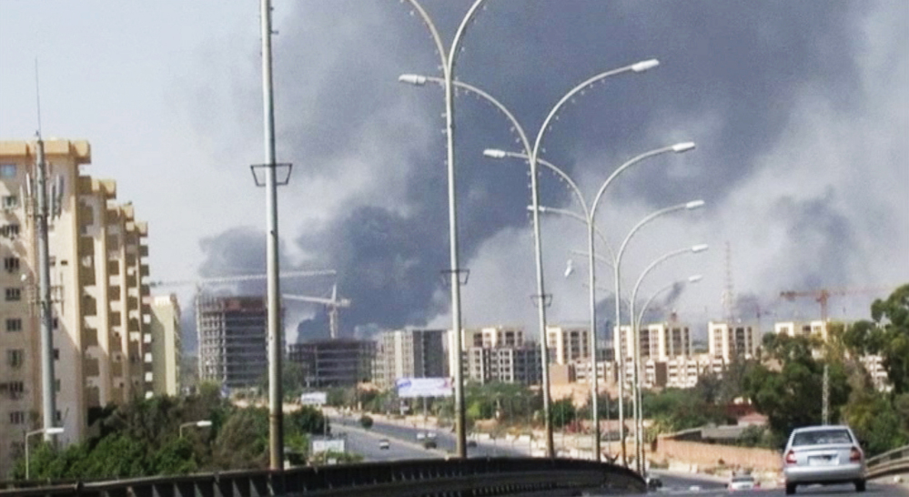 In this Sunday, July 13, 2014 file image made from video by The Associated Press, smoke rises from the direction of Tripoli airport in Tripoli, Libya.