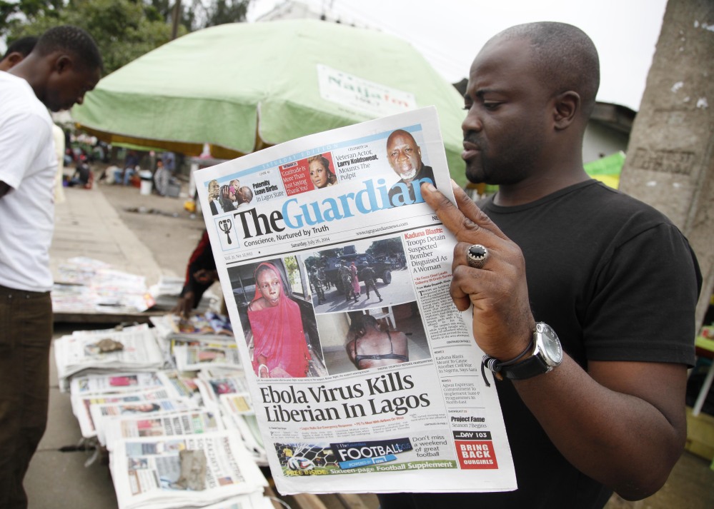 A man in Lagos, Nigeria, reads a local newspaper bearing a headline Saturday about the Ebola-caused death of a Liberian government worker who flew to Lagos from Togo.