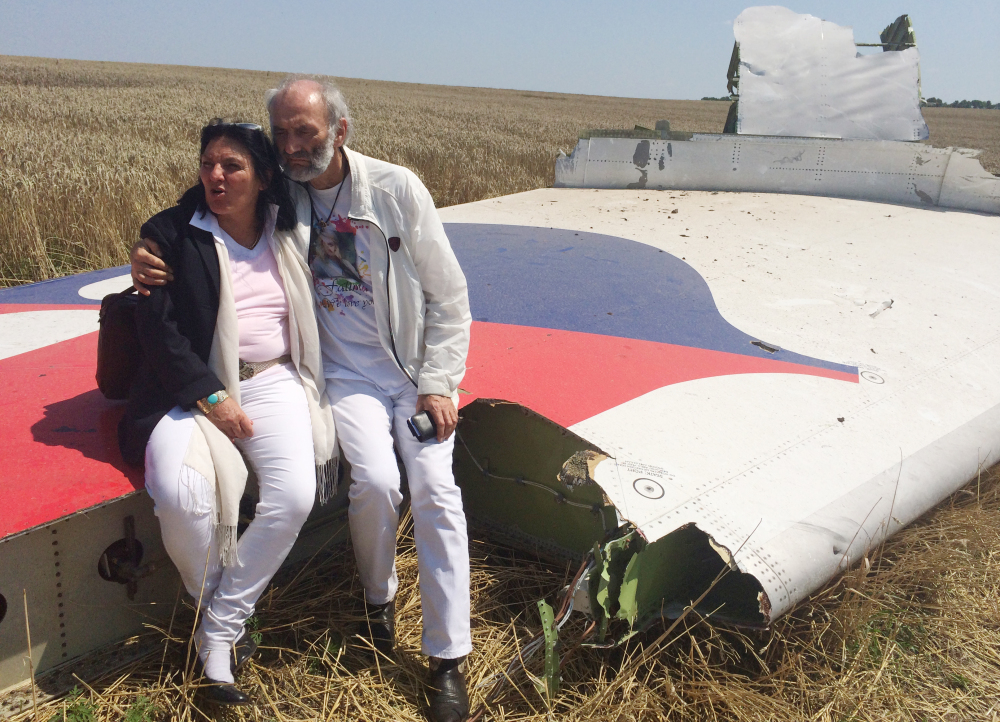 Jerzy Dyczynski and Angela Rudhart-Dyczynski whose daughter, 25-year-old Fatima, was a passenger on Malaysia Airlines flight MH17, sit on part of the wreckage of the crashed aircraft in Hrabove, Ukraine, on Saturday. The couple who live in Perth, Australia, crossed territory held by pro-Russian rebels to reach the wreckage-strewn farm fields outside the village of Hrabove. They last spoke to Fatima shortly before she boarded the flight for Kuala Lumpur in Amsterdam on July 17. The Associated Press