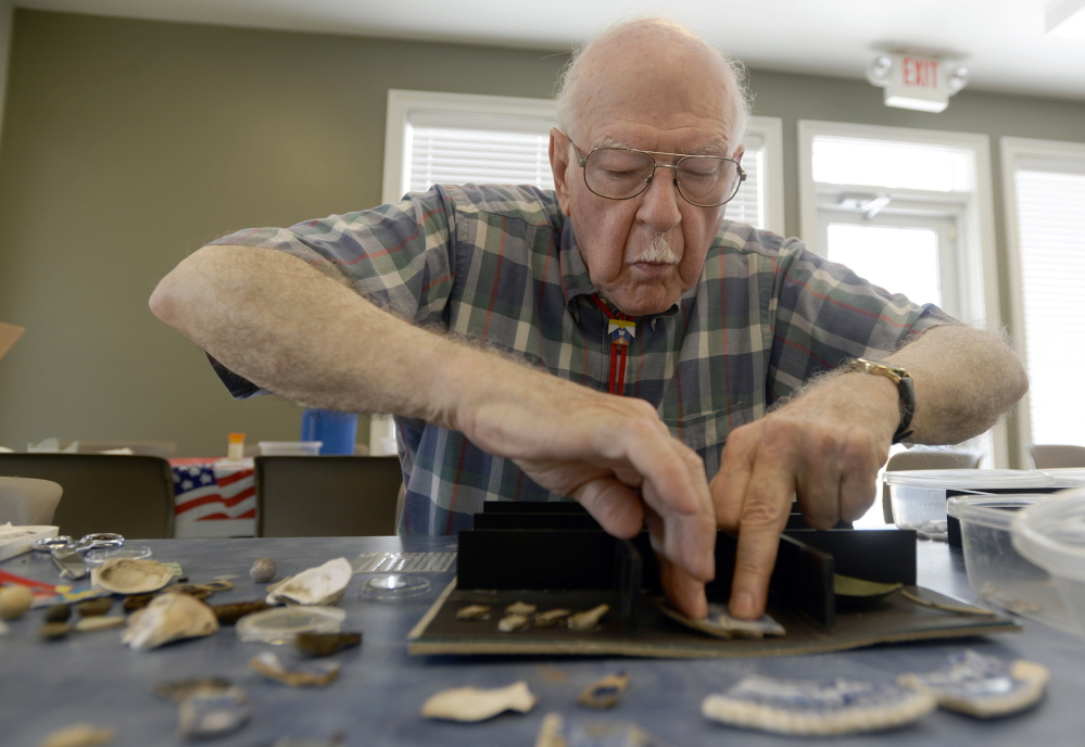 Volunteer Theodore Davi prepares a display with items excavated over the last eight years from the Avery hive site in Groton, Conn. The Associated Press/Tim Martin, The Day