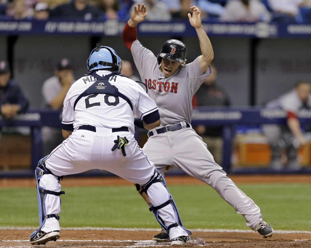 Boston’s Brock Holt tries to elude Tampa Bay catcher Jose Molina while attempting to score on a ground out by David Ortiz the third inning Saturday in St. Petersburg, Fla. Holt was tagged out.