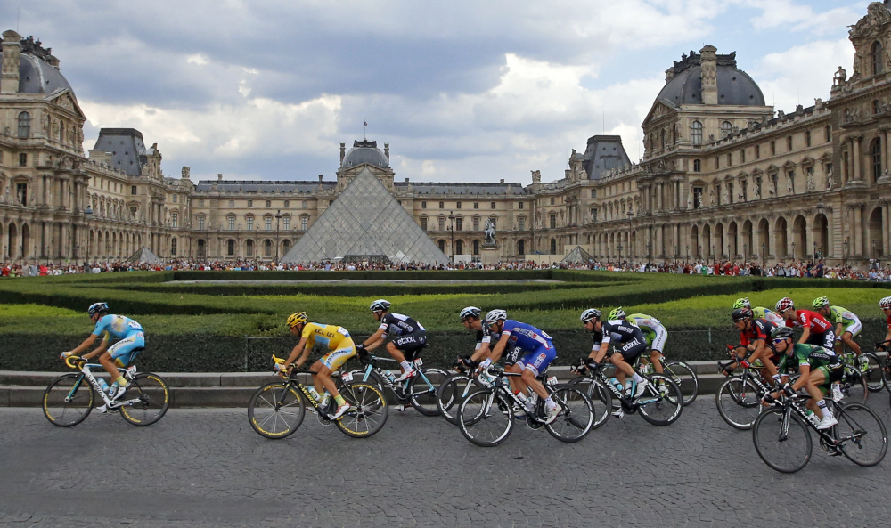 The pack, with Vincenzo Nibali of Italy, wearing the overall leader’s yellow jersey, left, rides through the courtyard of the Louvre museum, during the 21st and last stage of the Tour de France cycling race with finish in Paris, France, Sunday.