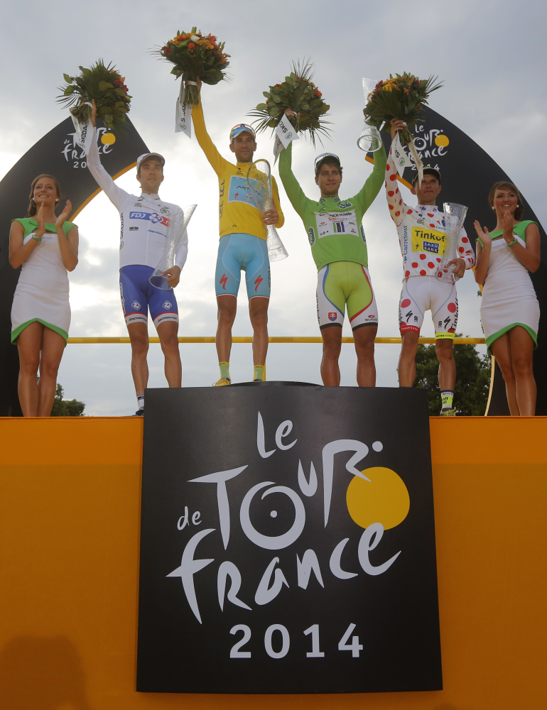 2014 Tour de France cycling race winner Vincenzo Nibali of Italy, wearing the overall leader’s yellow jersey, Peter Sagan of Slovakia, wearing the best sprinter’s green jersey, Rafal Majka of Poland, wearing the best climber’s dotted jersey, and Thibaut Pinot of France, wearing the best young rider’s white jersey, celebrate on the podium in Paris, France, Sunday.